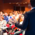 A man participates in a speech contest in an auditorium.