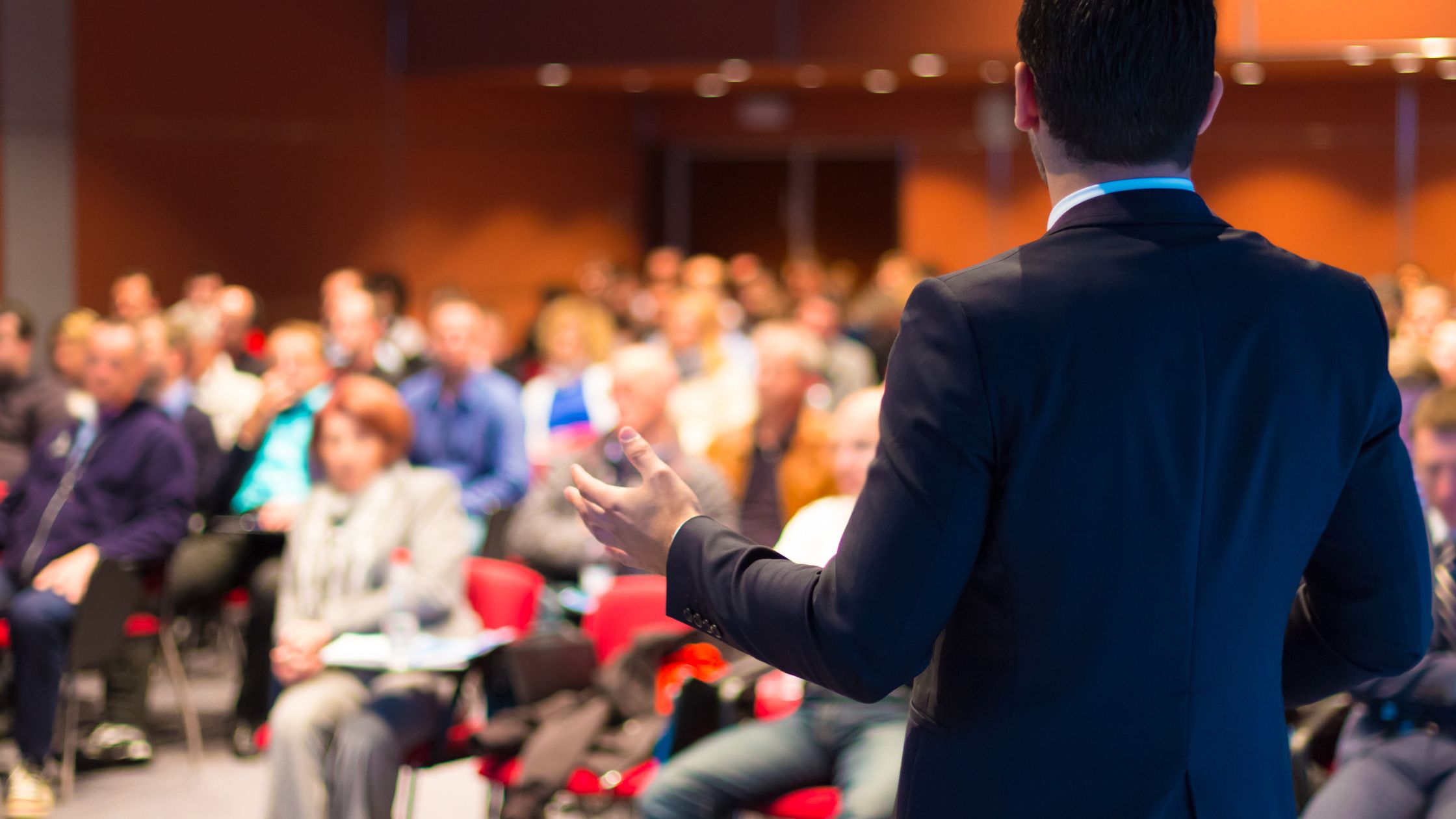 A man participates in a speech contest in an auditorium.