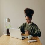 A young woman sits at her desk and views online training.