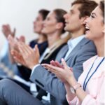 Audience members clap at the D7 Annual conference.